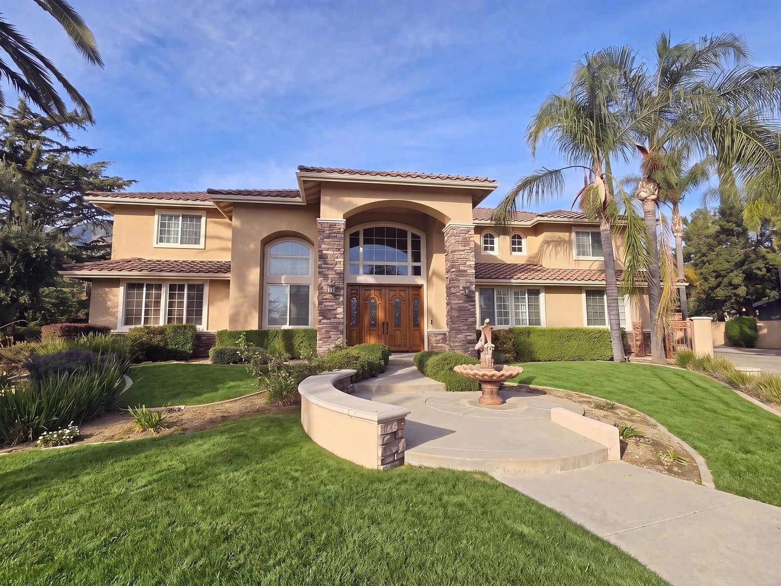 Mediterranean palette, digital rendering: golden tan stucco, cream trim, stacked stone and a stained wood door